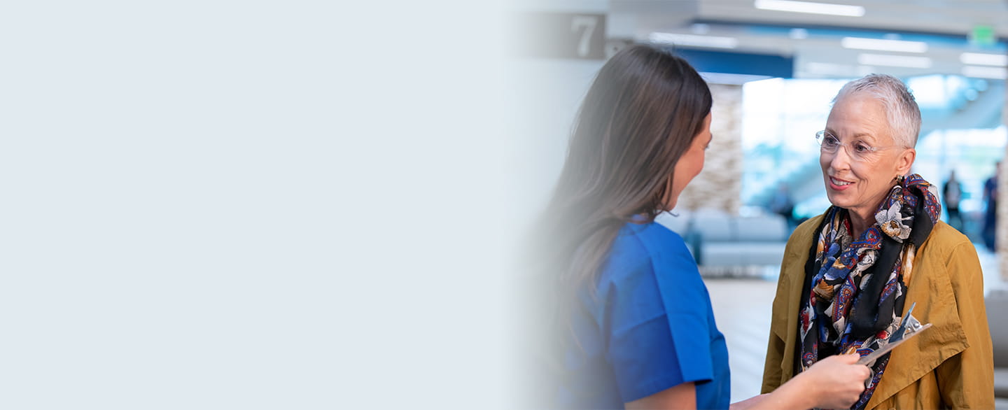 Nurse talking with patient in lobby.