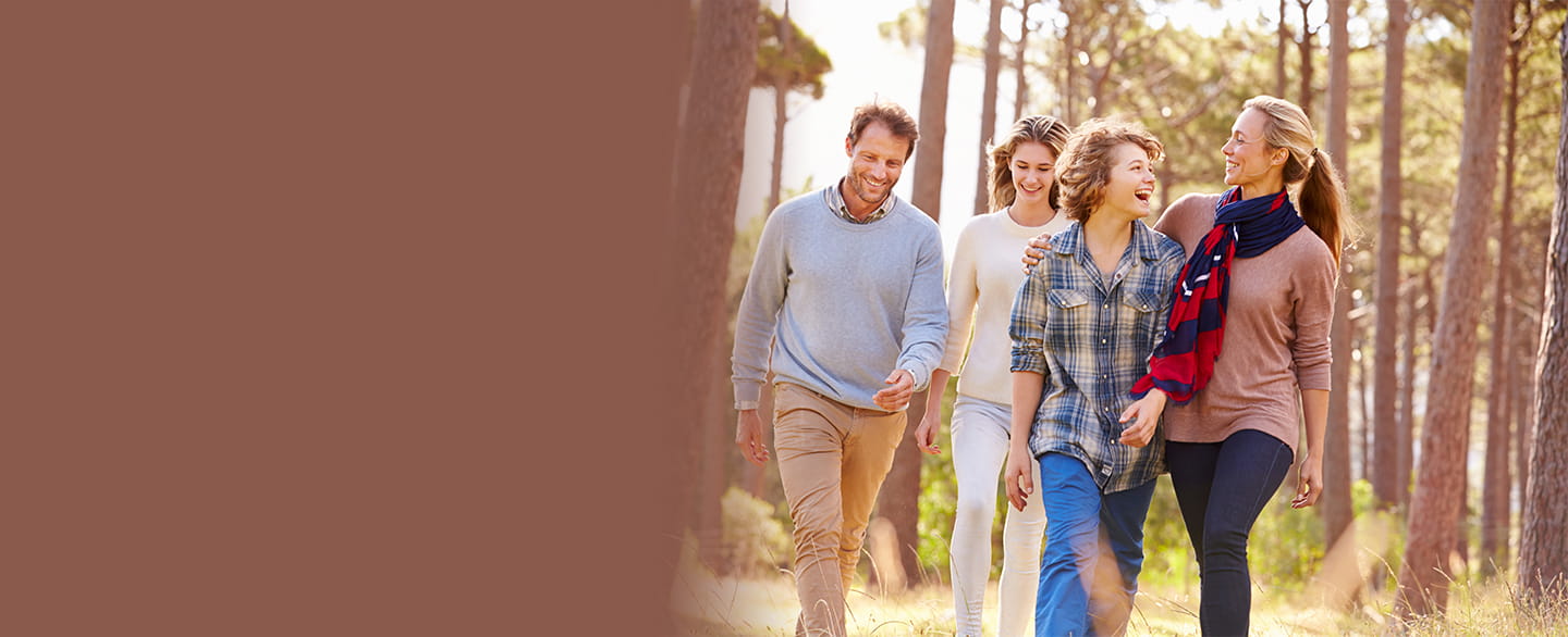 A family walking through a wooded area. 