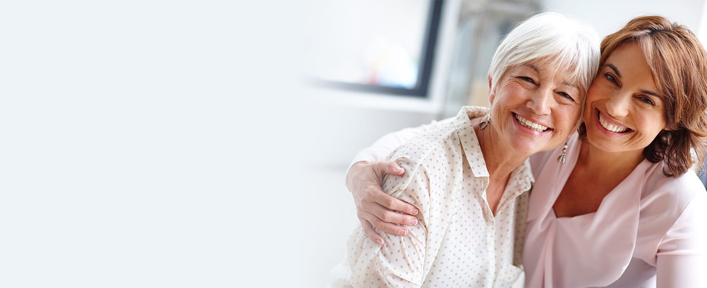 Mother and daughter hugging and smiling.
