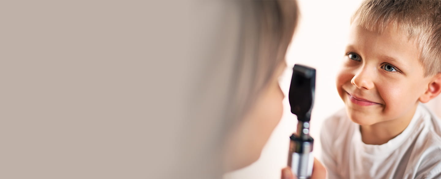 Doctor examining young boy's eyes.