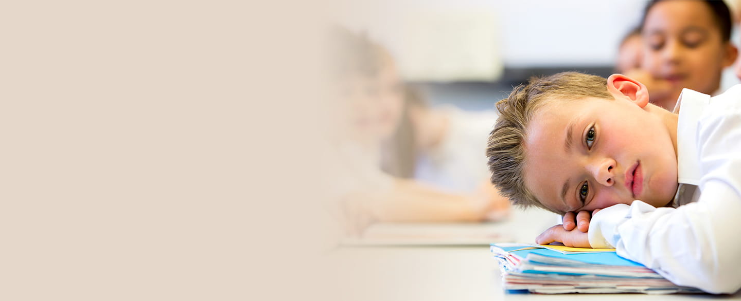 Young boy laying his head down on table.