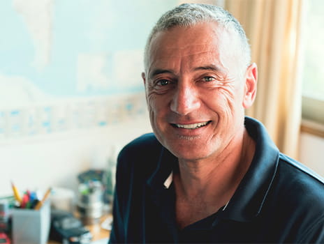 Middle aged man smiling at camera | a focus on men’s health improves urologic conditions