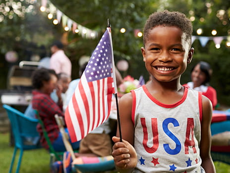 child smiling holding a flag