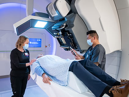 Doctors and patient using proton therapy for cancer treatment
