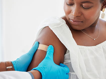 Doctor bandaging an injection site on a patient