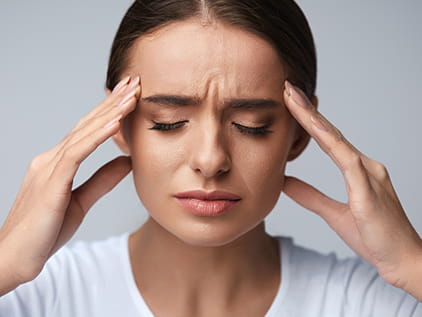 Girl holding her head with a headache. 