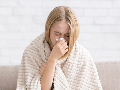 A sick person blowing their nose