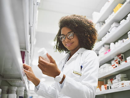 Pharmacist looking at a bottle of pills.