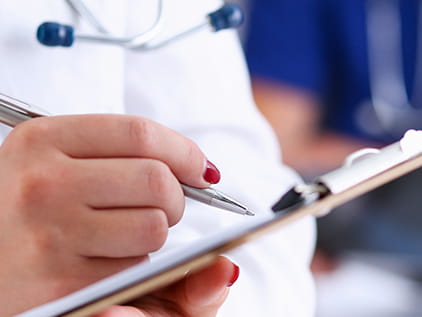 Doctor writing on a clipboard